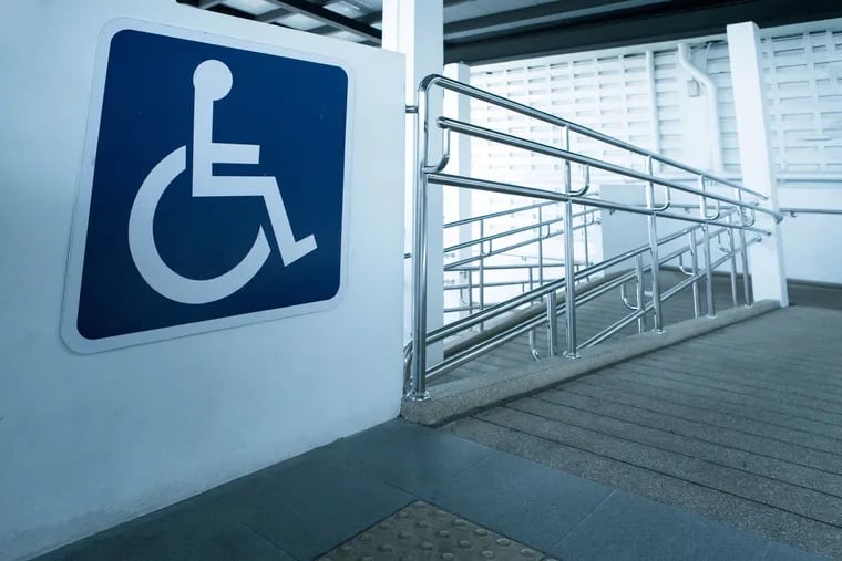 A ramp for people who use wheelchairs inside a building. Physical accessibility is one factor to consider in making sure a business complies with the Americans With Disabilities Act.